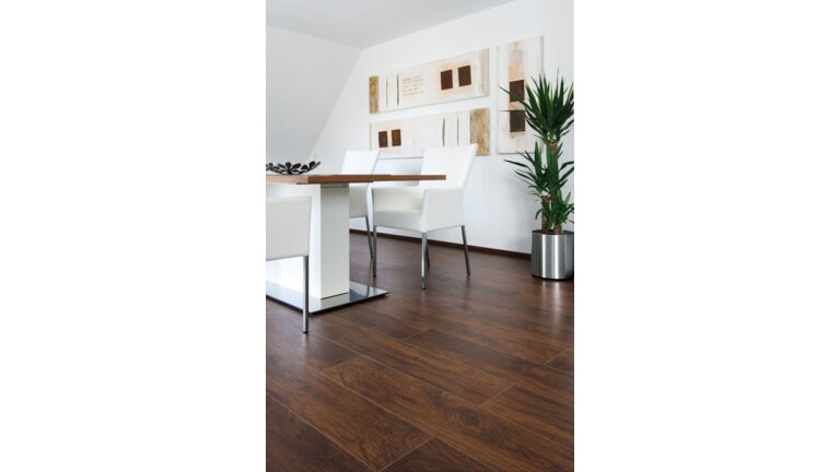 Modernes Esszimmer mit dunklem Holzboden.